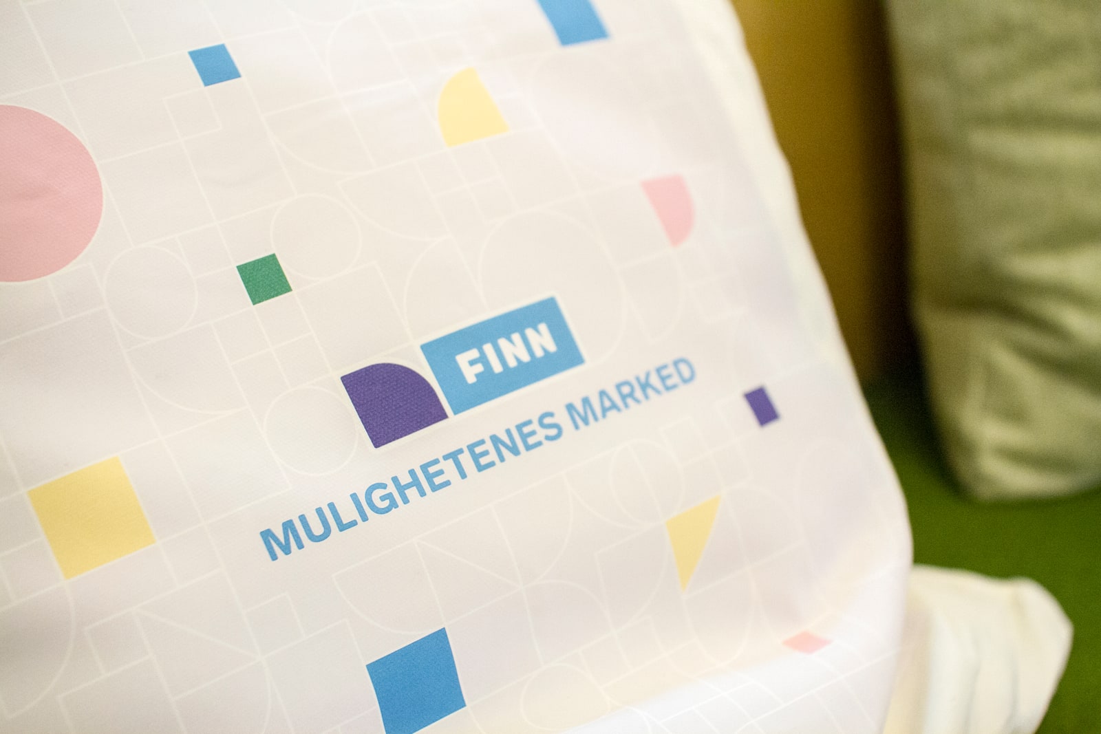 FINN-branded cushion with colorful geometric shapes